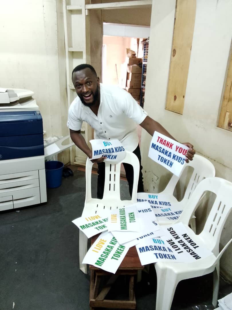 Person and children with Masaka Kids Africana sign